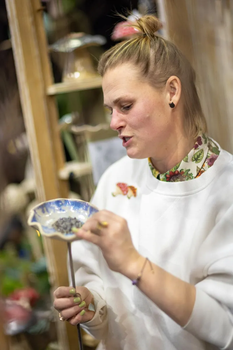 Zuzanna Hybiak maluje ceramiczne poidełko w pracowni